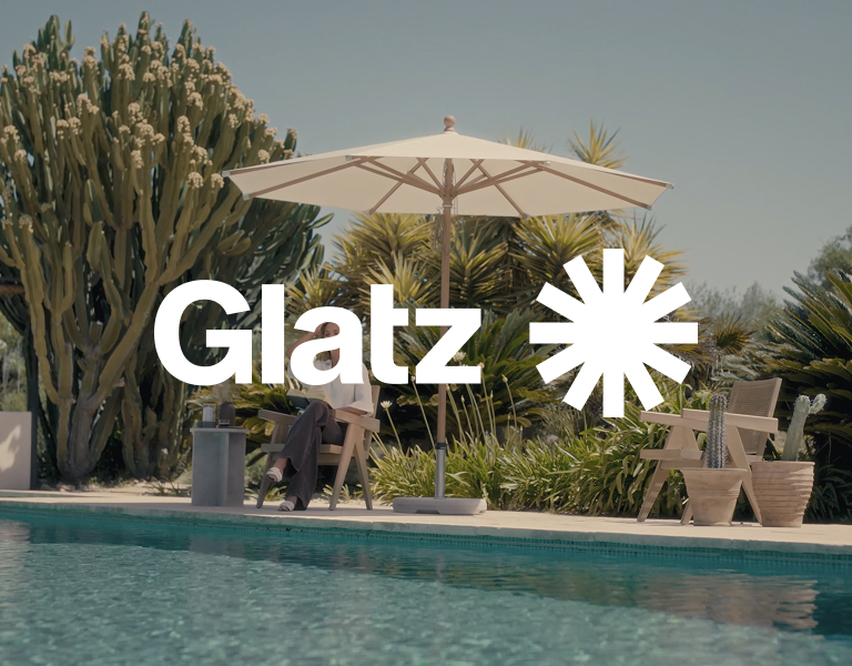 Glatz logo against a garden and pool setting
